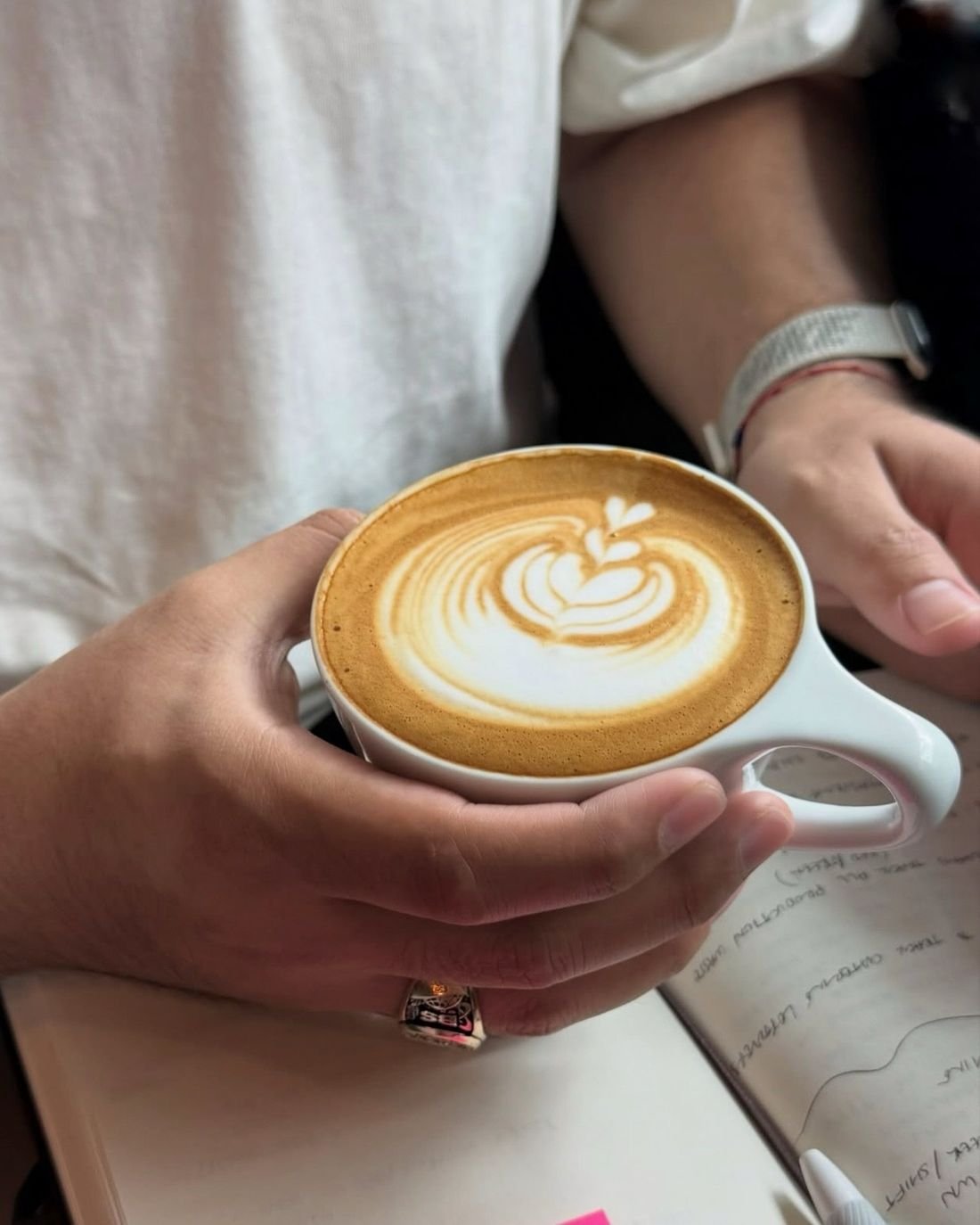 A guest holding a cappuccino with tulip latte art at Local Coffee